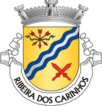 Escudo de ouro, barra ondada de azul e prata de três tiras, acompanhada de feixe de três setas abatidas, de vermelho, atadas de verde e de dois gládios alçados, de vermelho, realçados de prata e passados em aspa. Coroa mural de prata de três torres. Listel branco, com a legenda a negro: «RIBEIRA dos CARINHOS».