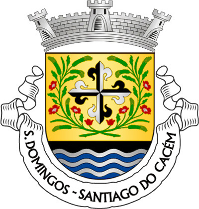 Escudo de ouro, com a cruz da Ordem de S. Domingos (cruz florenciada, gironada de negro e prata) entre dois ramos de espigas de trigo e papoilas, armadas em capela, tudo de sua cor; campanha de negro carregada de burelas ondeadas de prata e azul. Coroa mural de prata de três torres. Listel branco, com a legenda a negro, em maiúsculas: "S. DOMINGOS - SANTIAGO do CACÉM". 