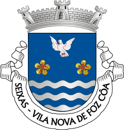 Escudo de azul, duas flores de amendoeira de ouro, botoadas e realçadas de vermelho, alinhadas em faixa; em chefe  uma pomba brava, volante, de prata, animada e armada de vermelho, campanha ondada de cinco peças de prata e azul. Coroa mural de três torres. Listel branco, com a legenda a negro: " SEIXAS - VILA NOVA DE FOZ CÔA"