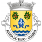 Escudo de ouro, mitra episcopal de azul com fanhões do mesmo, decorada, realçada e forrada de prata; em chefe, dois ramos de castanheiro de verde, com ouriços de ouro, abertos de vermelho; campanha diminuta ondada de azul e prata de três tiras. Coroa mural de prata de três torres. Listel branco, com a legenda a negro: «ALDEIA do BISPO - GUARDA». 