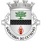 Escudo de prata, pano de muralha de negro, lavrado de prata e firmado nos flancos, acompanhado em chefe de uma oliveira arrancada de verde e frutada de negro e, em campanha, de uma lanterna de mineiro de vermelho, acesa e realçada de ouro. Coroa mural de prata de quatro torres. Listel branco, com a legenda a negro: "SALVATERRA do EXTREMO".