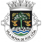 Escudo de negro, com uma amendoeira de verde florida de prata e saínte de um contra-chefe de verde rematado de rochas de prata realçado de verde, cortada por três faixas ondadas, duas de prata e uma de azul. Amendoeira acompanhada por duas trompas de caça de ouro forradas de vermelho, sustendo dois falcões de sua cor e acantonado em chefe por dois nós de corda, de ouro. Coroa mural de prata de cinco torres. Listel branco com os dizeres a negro : "VILA NOVA DE FOZ CÔA".