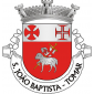 Escudo de vermelho, Agnus Dei, de prata com lábaro do mesmo, carregado de uma cruz firmada de vermelho e haste de ouro; chefe de prata, carregado das cruzes da Ordem dos Templários e da Ordem de Cristo. Coroa mural de prata de três torres. Listel branco com a legenda de negro, em maiúsculas : “ S. JOÃO BAPTISTA – TOMAR “.