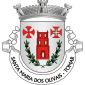 Escudo de prata, torre torreada de vermelho, iluminada e aberta do campo, encerrada numa orla de ramos de oliveira de verde, frutados de negro, com os pés passados em aspa; em chefe, cruz dos Templários de vermelho à dextra e cruz da Ordem de Cristo de vermelho e aberta do campo, à sinistra. Coroa mural de prata de três torres. Listel branco com a legenda de negro, em maiúsculas : “SANTA MARIA DOS OLIVAIS - TOMAR“. (D.R.III Série nº 239, de 13/10/99)