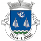 Escudo de azul, dragão de prata lampassado, animado e armado de vermelho e duas velas de embarcação de prata, armadas em mastro e cordame de negro, tudo alinhado em roquete; campanha diminuta ondada de prata e verde de três peças. Coroa mural de prata de três torres. Listel branco, com a legenda a negro: «VELAS - S. JORGE». 