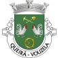 Escudo de verde, com dois galos de prata, cristados, barbaleados, bicados e armados de vermelho, postos em cortesia; em chefe, uma picareta e uma pá de ouro, com os cabos passados em aspa; em ponta, roda de moínho de ouro, realçada de negro. Coroa mural de prata de três torres. Listel branco, com a legenda a negro: «QUEIRÃ - VOUZELA». 