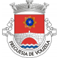 Escudo vermelho, ponte de prata de um arco, lavrada de negro, movente dos flancos e de um pé ondado de prata e azul
de três tiras; em chefe, uma rosa heráldica de azul, botonada de prata e apontada de verde, nimbada e raiada de ouro. Coroa mural de prata de três torres. Listel branco, com a legenda a negro «FREGUESIA DE VOUZELA». 